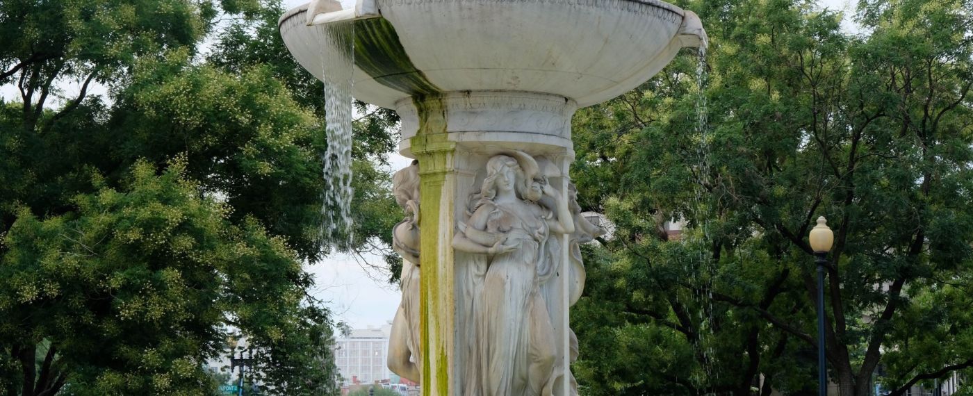 A Fountain In Front Of A Statue